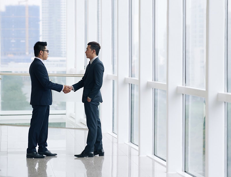 Image of two business men shaking hands in a building
